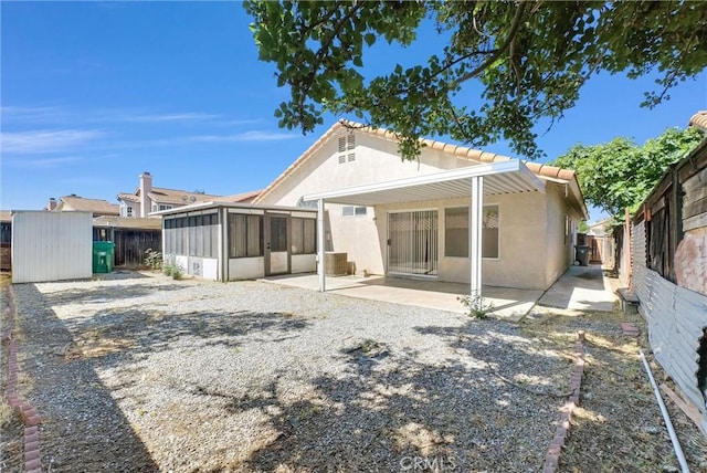 12820 Pan Am Blvd, Moreno Valley, CA 92553 - rear view of property featuring a sunroom, stucco siding, a fenced backyard, a storage unit, and an outbuilding