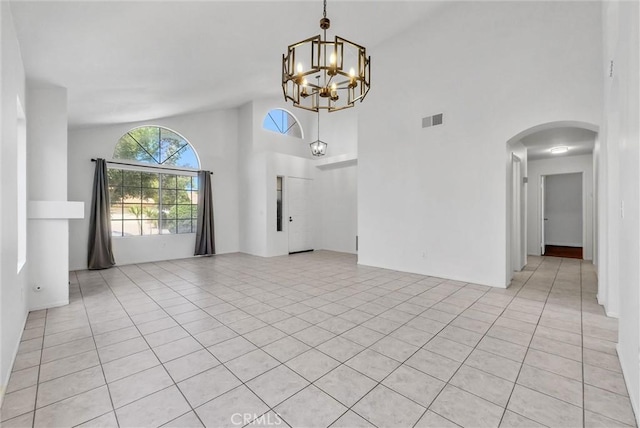 12820 Pan Am Blvd, Moreno Valley, CA 92553 - spare room featuring a chandelier, high vaulted ceiling, arched walkways, and light tile patterned floors