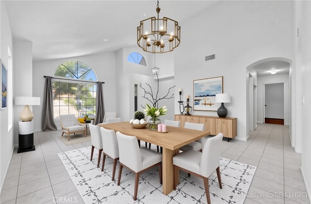 12820 Pan Am Blvd, Moreno Valley, CA 92553 - dining area featuring arched walkways, a chandelier, light tile patterned floors, high vaulted ceiling, and baseboards