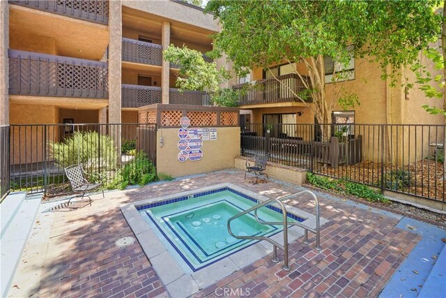 22100 Burbank Blvd Unit 150F, Woodland Hills, CA 91367 - view of pool featuring a community hot tub and fence