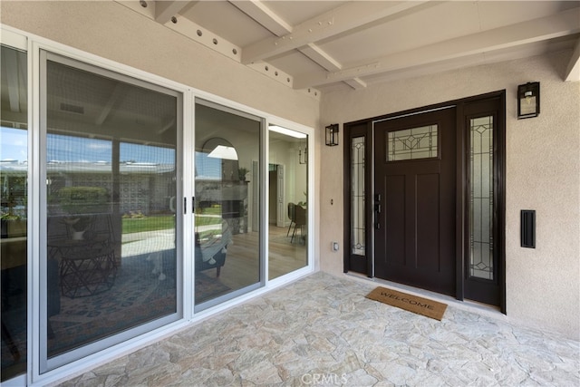 doorway to property featuring stucco siding