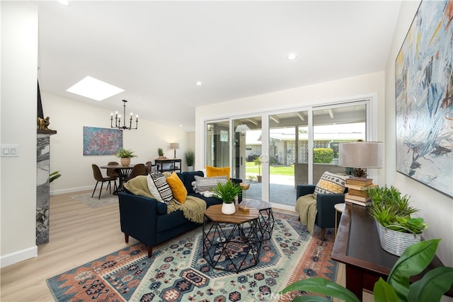 living room with a skylight, wood finished floors, a chandelier, baseboards, and recessed lighting