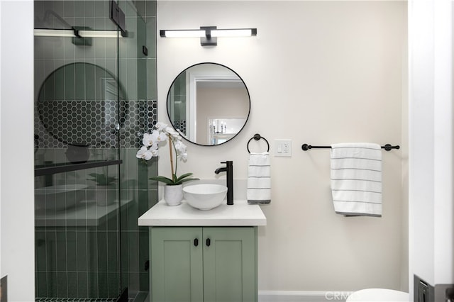 bathroom with a tile shower, vanity, and toilet