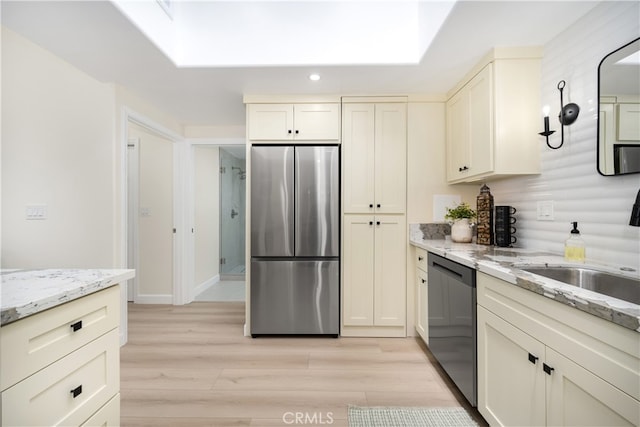 kitchen featuring stainless steel appliances, light wood-type flooring, recessed lighting, and light stone counters