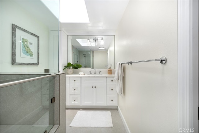 bathroom with vanity, a stall shower, and baseboards