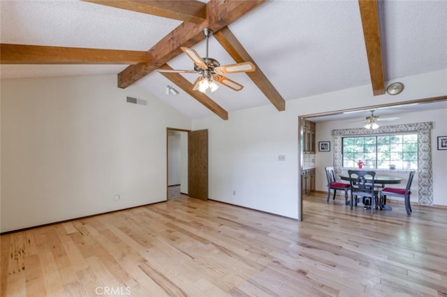 unfurnished living room with ceiling fan, light wood finished floors, and a textured ceiling