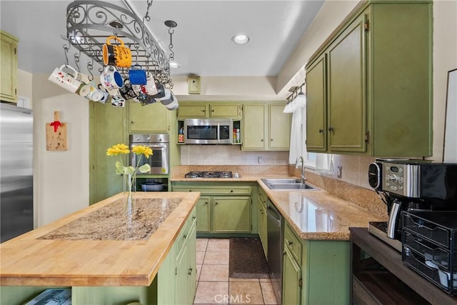 19853 Drasin Dr, Canyon Country, CA 91351 - kitchen featuring green cabinetry, a sink, appliances with stainless steel finishes, light tile patterned flooring, and a kitchen island
