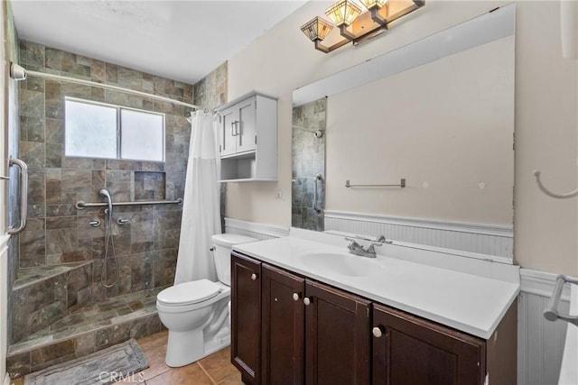 19853 Drasin Dr, Canyon Country, CA 91351 - bathroom featuring a wainscoted wall, toilet, a tile shower, vanity, and tile patterned floors
