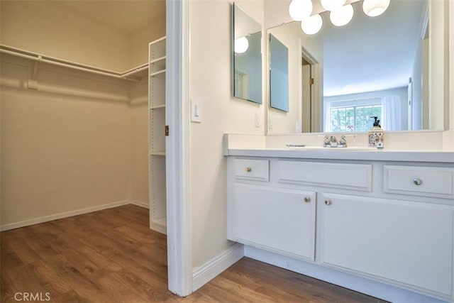 111 Greenfield, Irvine, CA 92614 - bathroom with wood finished floors, vanity, a spacious closet, and baseboards