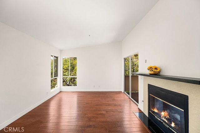 5140 Twilight Canyon Rd Unit 27H, Yorba Linda, CA 92887 - unfurnished living room with plenty of natural light, a glass covered fireplace, wood finished floors, baseboards, and vaulted ceiling