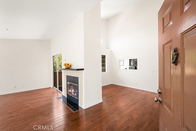 5140 Twilight Canyon Rd Unit 27H, Yorba Linda, CA 92887 - unfurnished living room with a high ceiling, wood finished floors, a glass covered fireplace, and baseboards