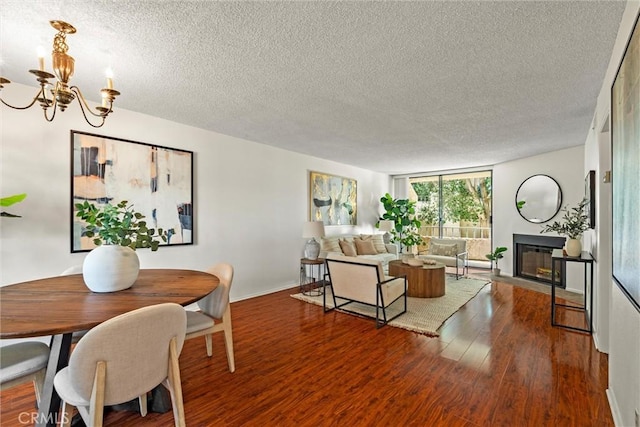 4141 Via Marisol Unit 215, Los Angeles, CA 90042 - living area featuring a textured ceiling, a chandelier, a glass covered fireplace, wood finished floors, and baseboards