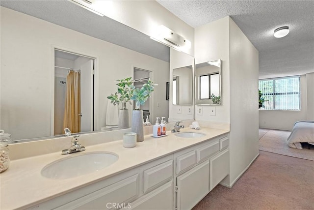 4141 Via Marisol Unit 215, Los Angeles, CA 90042 - ensuite bathroom featuring a textured ceiling and double vanity