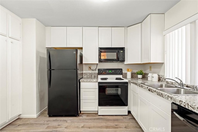 4141 Via Marisol Unit 215, Los Angeles, CA 90042 - kitchen with black appliances, a sink, light wood-type flooring, white cabinets, and light countertops