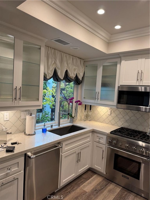 28185 Via Luis, Laguna Niguel, CA 92677 - kitchen with appliances with stainless steel finishes, a sink, ornamental molding, dark wood-style floors, and a raised ceiling