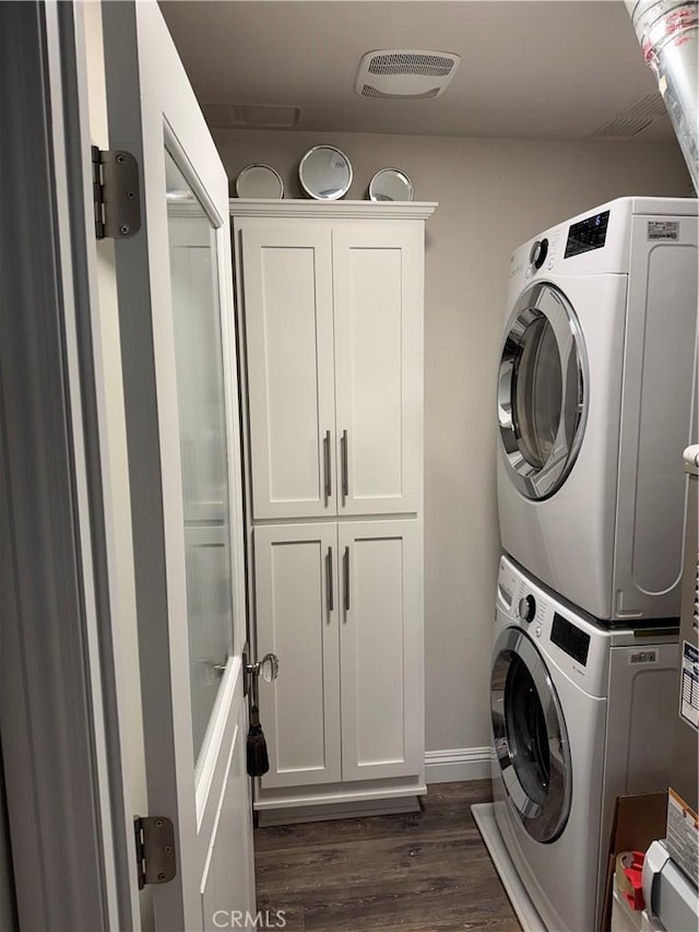 28185 Via Luis, Laguna Niguel, CA 92677 - laundry area with estacked washer and dryer, dark wood-style floors, cabinet space, and baseboards