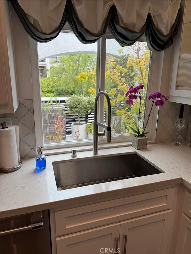 28185 Via Luis, Laguna Niguel, CA 92677 - kitchen view of a sink, decorative backsplash, light stone counters, and dishwashing machine
