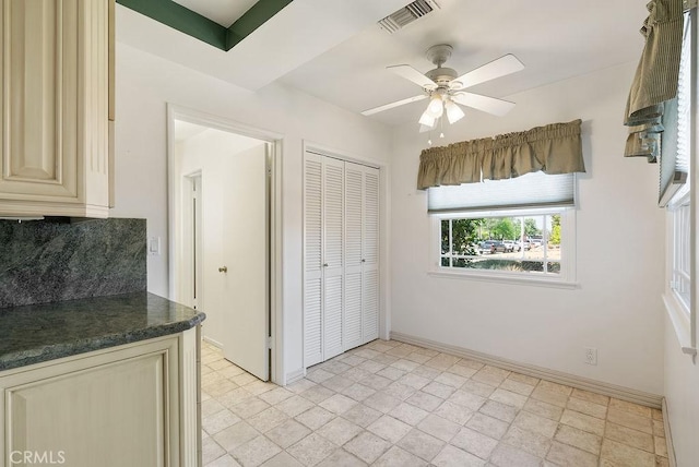 338 S La Serena Dr, West Covina, CA 91791 - kitchen with cream cabinets, dark countertops, ceiling fan, baseboards, and tasteful backsplash