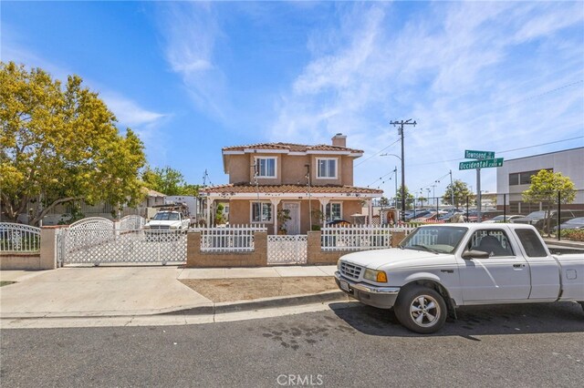 1709 S Townsend St, Santa Ana, CA 92704 - view of front of property with a gate, a chimney, a fenced front yard, a tiled roof, and stucco siding