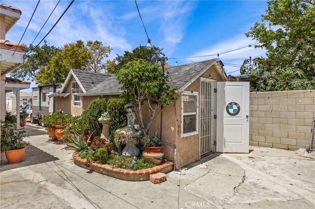 1709 S Townsend St, Santa Ana, CA 92704 - view of front of property with stucco siding, an outdoor structure, and roof with shingles