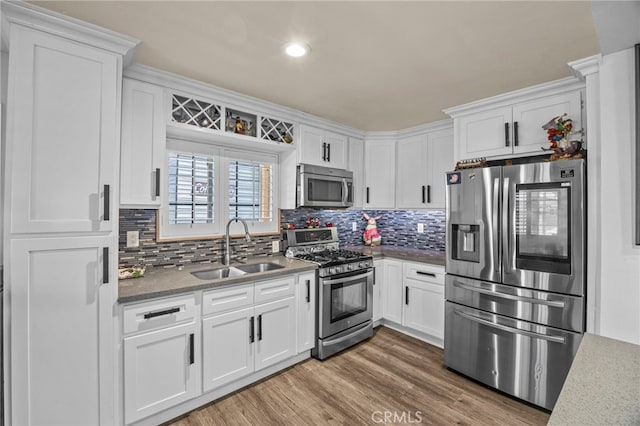 1709 S Townsend St, Santa Ana, CA 92704 - kitchen with stainless steel appliances, a sink, white cabinets, decorative backsplash, and wood finished floors