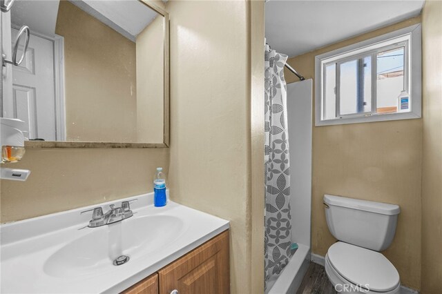 1709 S Townsend St, Santa Ana, CA 92704 - bathroom featuring toilet, vanity, curtained shower, and wood finished floors