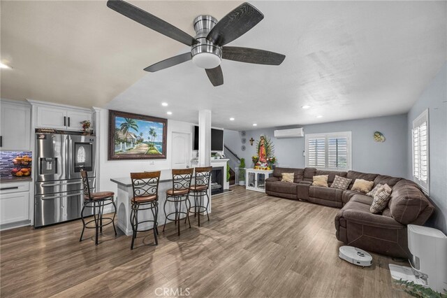 1709 S Townsend St, Santa Ana, CA 92704 - living area featuring a wall mounted air conditioner, wood finished floors, recessed lighting, and ceiling fan