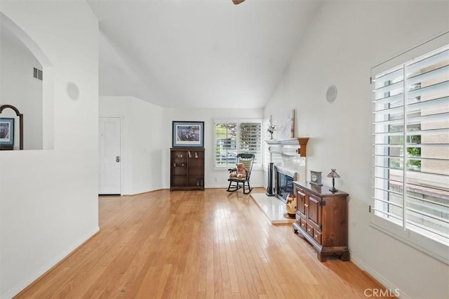 28613 Apricot Pl, Valencia, CA 91390 - living room with arched walkways, lofted ceiling, light wood finished floors, a glass covered fireplace, and baseboards