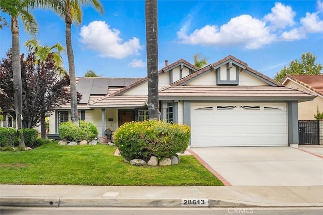 28613 Apricot Pl, Valencia, CA 91390 - view of front of property featuring a tiled roof, an attached garage, roof mounted solar panels, a front lawn, and concrete driveway