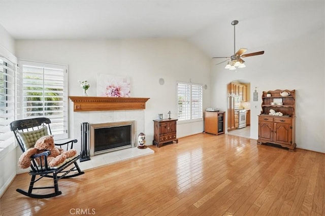 28613 Apricot Pl, Valencia, CA 91390 - living room featuring wood finished floors, a tiled fireplace, arched walkways, ceiling fan, and high vaulted ceiling
