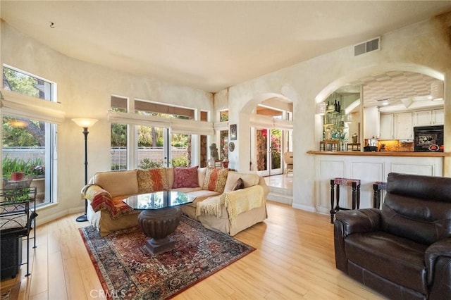 81 Via Barcaza, Coto De Caza, CA 92679 - living room featuring light wood-style floors, arched walkways, healthy amount of natural light, and a high ceiling