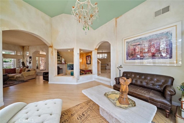 81 Via Barcaza, Coto De Caza, CA 92679 - living area featuring arched walkways, a chandelier, healthy amount of natural light, wood finished floors, and high vaulted ceiling