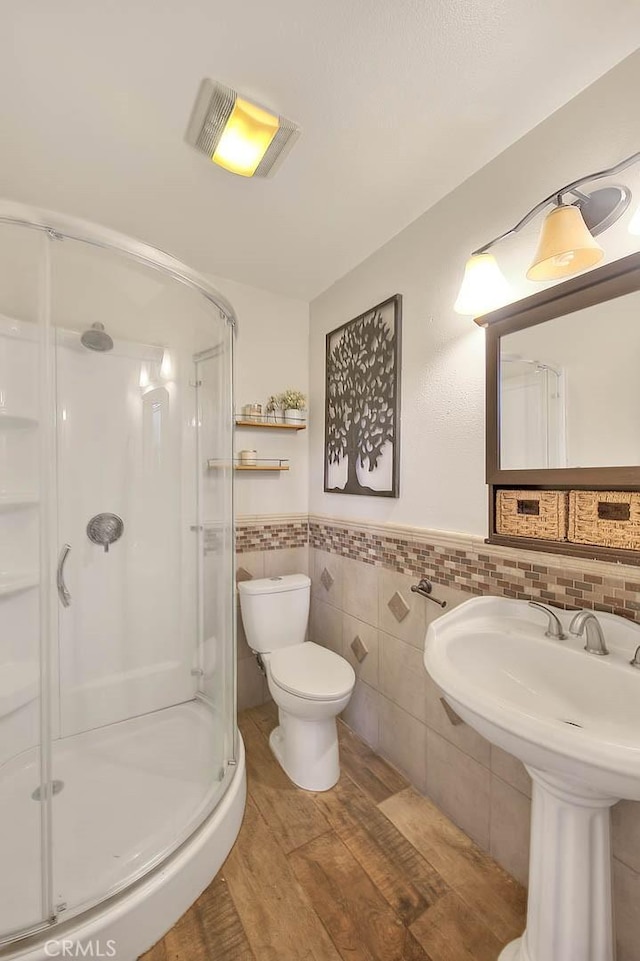 13023 Avenida Empresa, Riverside, CA 92503 - bathroom featuring a shower stall, tile walls, a wainscoted wall, and wood finished floors