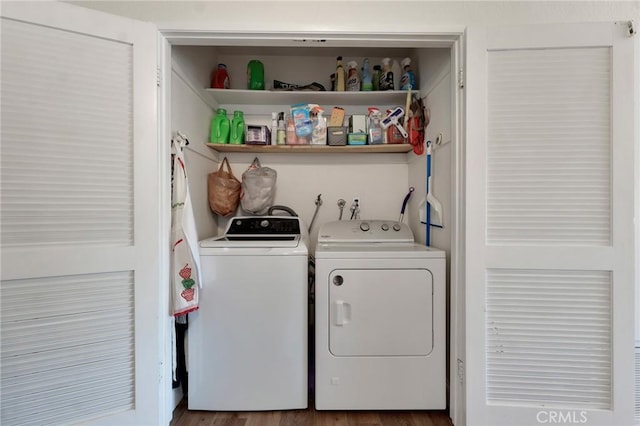 clothes washing area featuring washing machine and dryer and wood finished floors