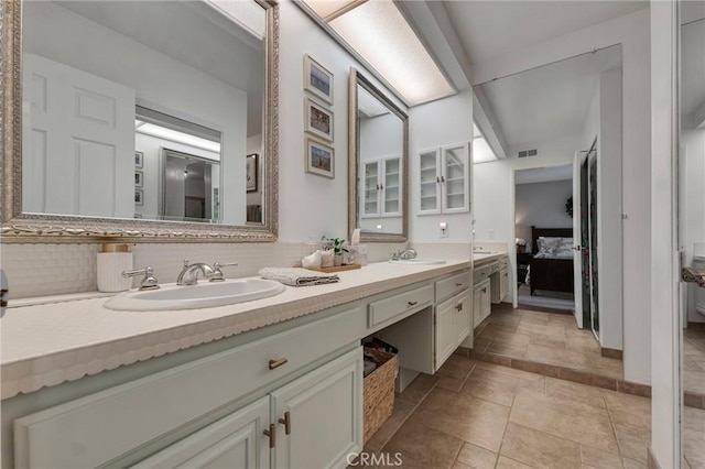 bathroom featuring ensuite bath, double vanity, and tasteful backsplash