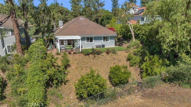 rear view of house featuring fence, a chimney, stucco siding, and a patio area