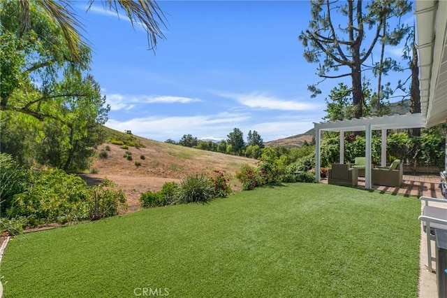 view of green lawn with a pergola, outdoor lounge area, and a mountain view