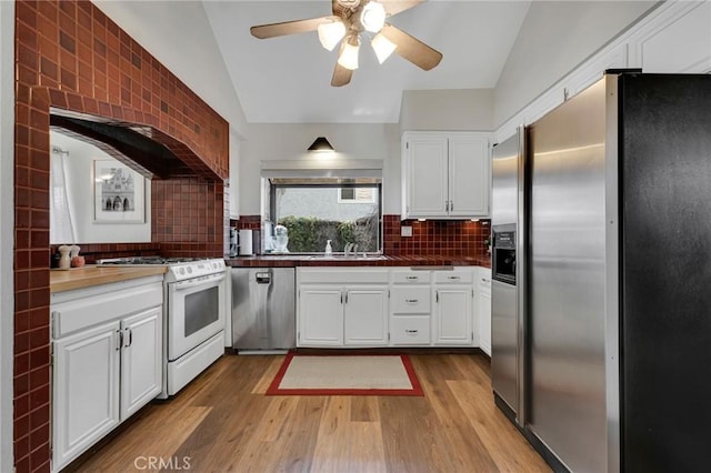 kitchen with appliances with stainless steel finishes, lofted ceiling, white cabinets, ceiling fan, and wood finished floors