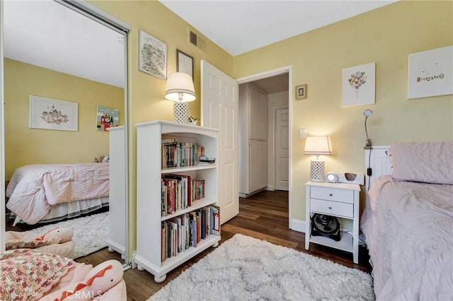 bedroom with wood finished floors and baseboards