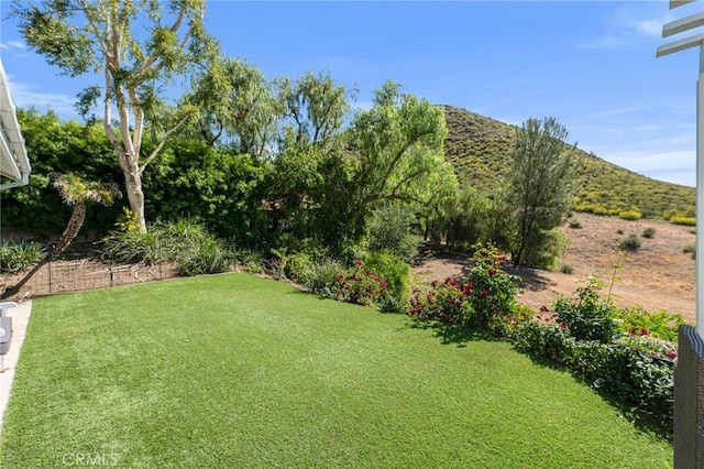 view of green lawn featuring a mountain view