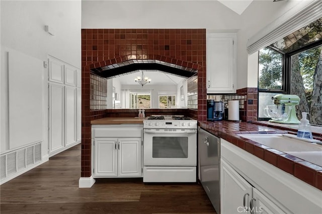 kitchen featuring white gas stove, a chandelier, healthy amount of natural light, white cabinetry, and vaulted ceiling