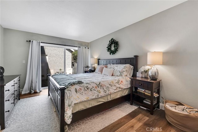 bedroom with access to exterior and dark wood-type flooring