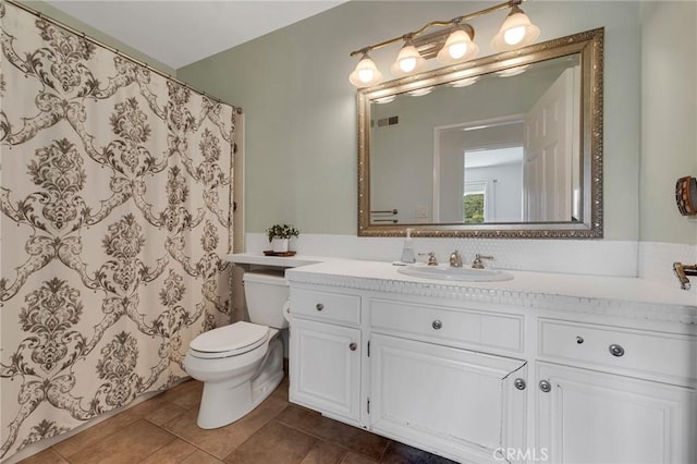 bathroom featuring toilet, vanity, tile patterned flooring, and a shower with curtain
