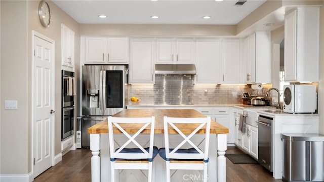 11815 Briarrose Ln, Chino, CA 91710 - kitchen featuring appliances with stainless steel finishes, under cabinet range hood, white cabinets, dark wood finished floors, and recessed lighting
