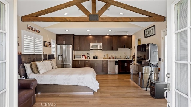 bedroom featuring stainless steel fridge, beamed ceiling, light wood-type flooring, a sink, and recessed lighting