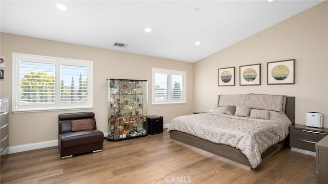 bedroom with wood finished floors, baseboards, recessed lighting, and vaulted ceiling