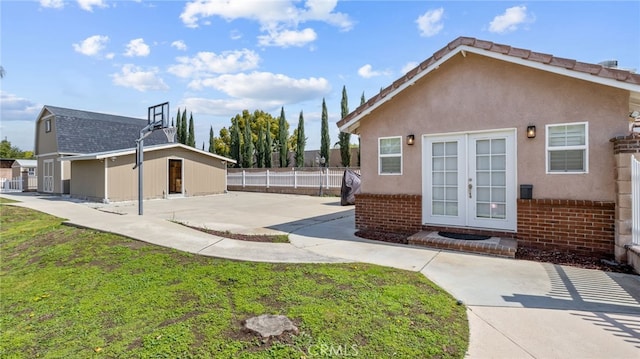 back of property with brick siding, french doors, and a patio area
