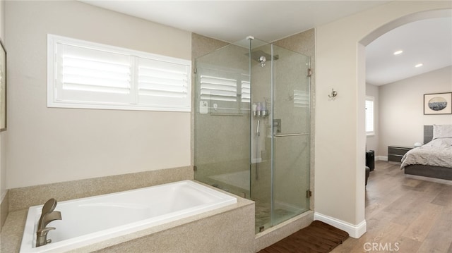 full bath with connected bathroom, a shower stall, a bath, wood finished floors, and recessed lighting
