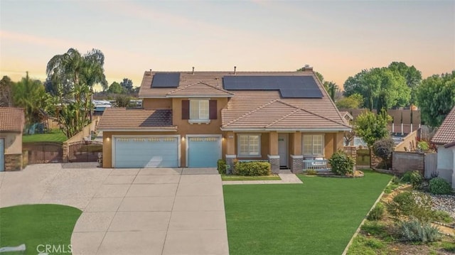 view of front of home featuring concrete driveway, a porch, roof mounted solar panels, and a tile roof