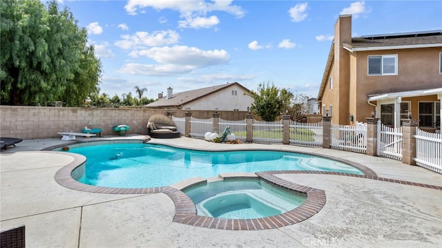 view of pool with a patio, a fenced backyard, and a pool with connected hot tub
